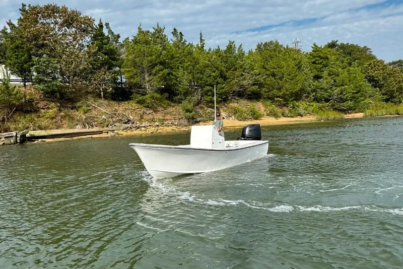 Slide: The Image of 2025 Privateer 20 Roamer boat cruising on a calm river near a wooded shoreline. - 13