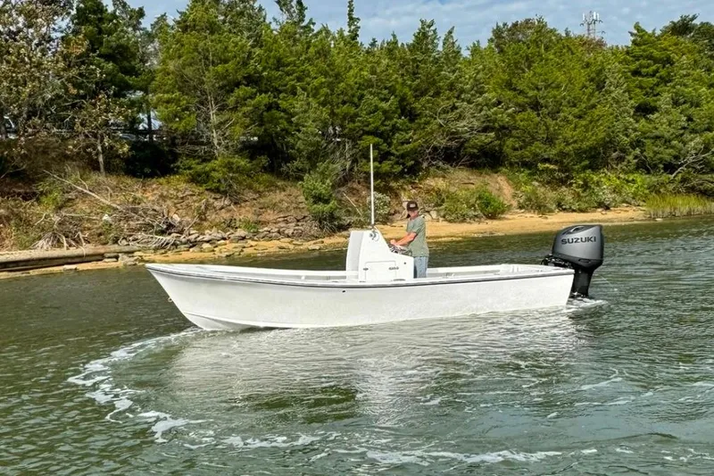 Slide: The Image of 2025 Privateer 20 Roamer boat cruising on a calm river near a wooded shoreline. - 15