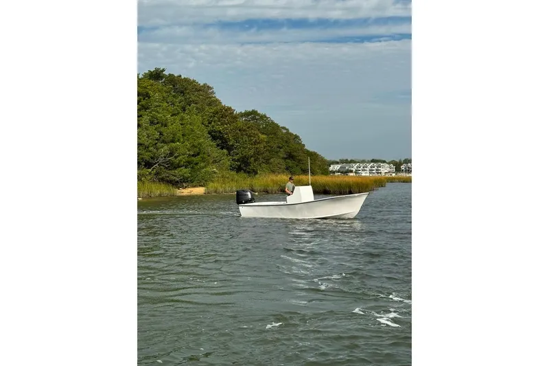 Slide: The Image of 2025 Privateer 20 Roamer boat cruising on a scenic river with lush greenery. - 19