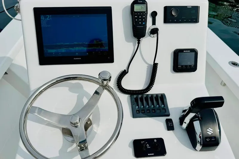 Slide: The Image of Control panel of 2025 Privateer 20 Roamer boat with steering wheel and electronic devices. - 24