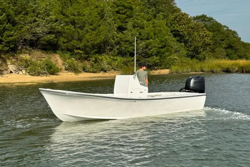Slide: The Image of 2025 Privateer 20 Roamer boat cruising near a lush, green shoreline. - 4