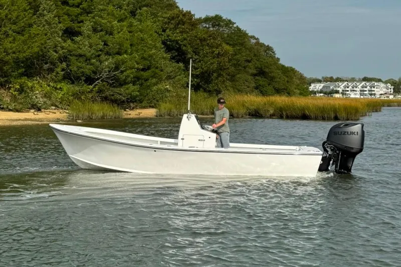 Slide: The Image of 2025 Privateer 20 Roamer boat with Suzuki engine cruising on a scenic waterway. - 5