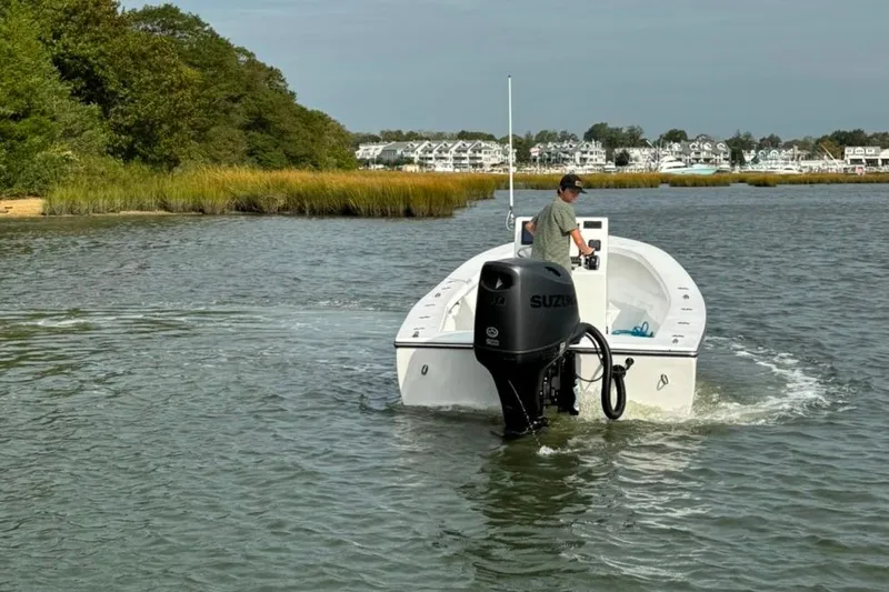 Slide: The Image of A 2025 Privateer 20 Roamer boat navigating a calm waterway with scenic shoreline. - 7