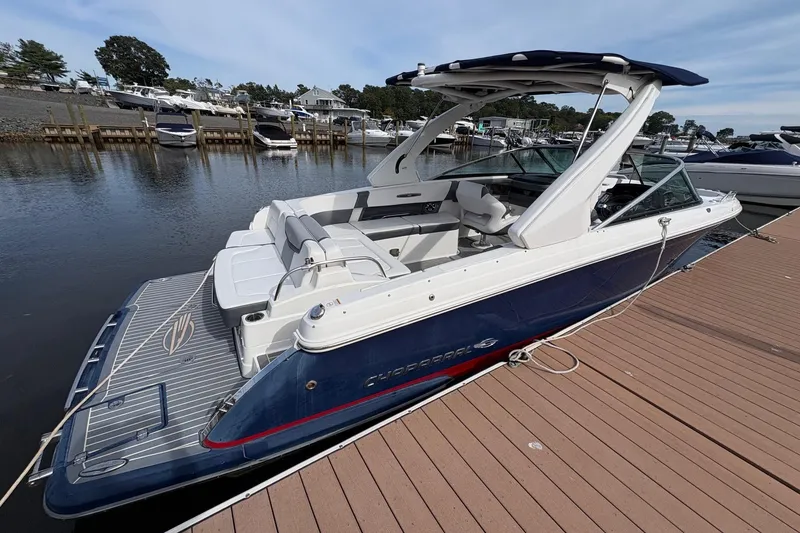 Slide: The Image of 2018 CHAPPARAL 287 SSX boat docked on calm water, featuring sleek design and spacious seating. - 11
