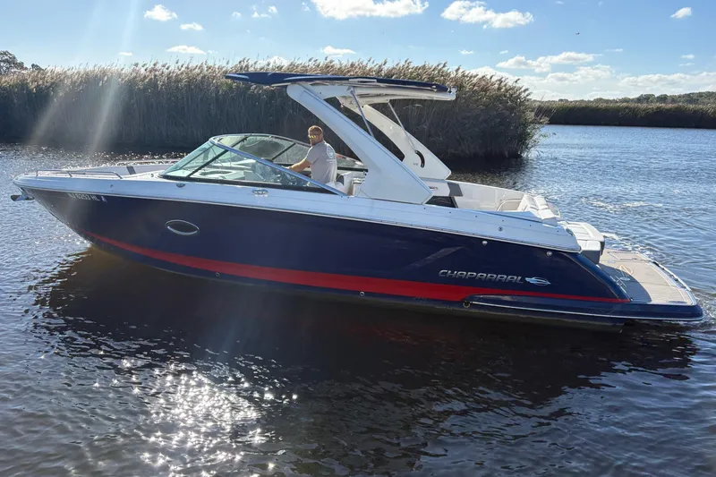 Slide: The Image of 2018 Chaparral 287 SSX boat on a sunny day, cruising on calm waters. - 2