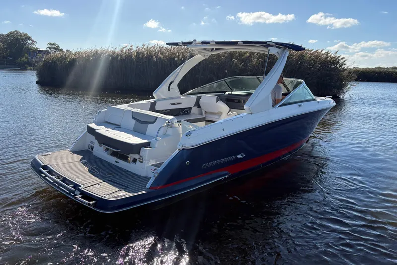 Slide: The Image of 2018 Chaparral 287 SSX boat on calm water under clear blue sky. - 4