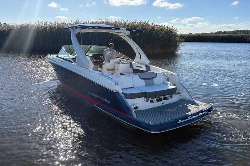 Slide: The Image of 2018 Chaparral 287 SSX boat on water, rear view with seating and deck. - 7