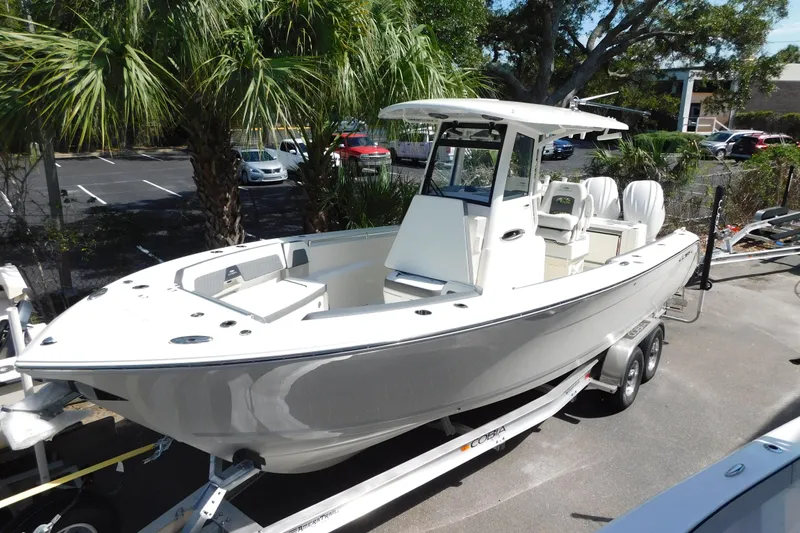 The Image of 2026 Cobia 285 Center Console boat on display with lush greenery background. - 0