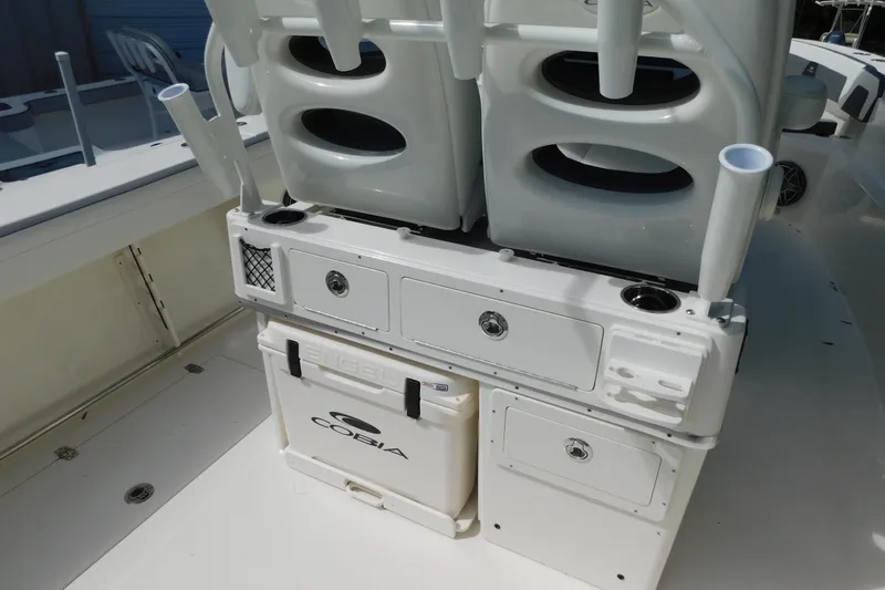 Slide: The Image of 2026 Cobia 285 Center Console boat door with stainless steel hardware and cushioned seating. - 14