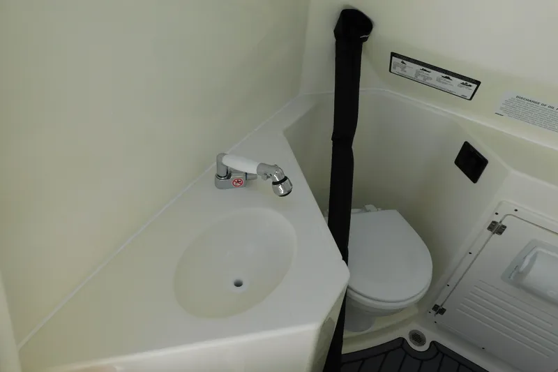 Slide: The Image of 2026 Cobia 285 Center Console boat interior with compact bathroom and modern fixtures. - 32