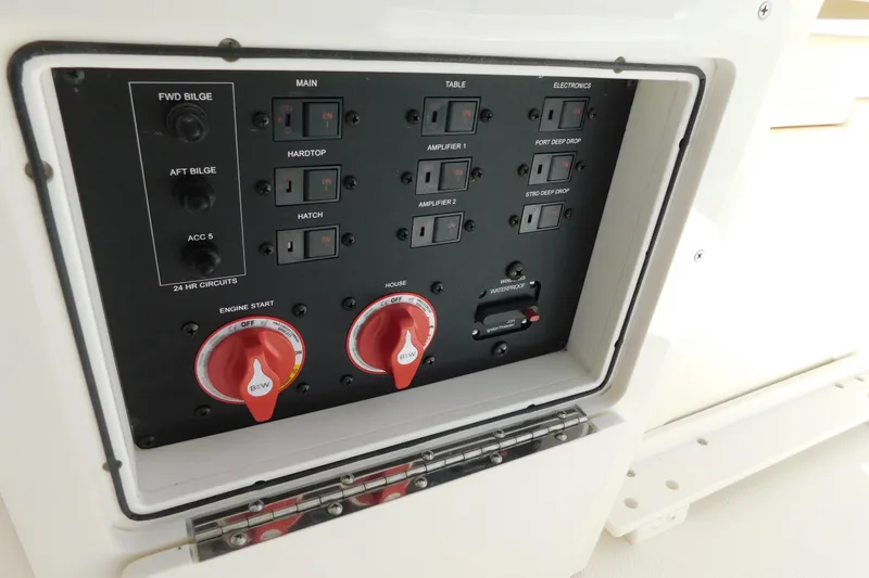 Slide: The Image of 2026 Cobia 285 Center Console dashboard with compass, docked near other boats. - 44