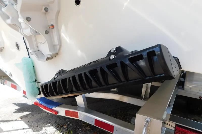 Slide: The Image of Twin outboard motors on a 2026 Cobia 285 Center Console boat, parked on a trailer. - 49