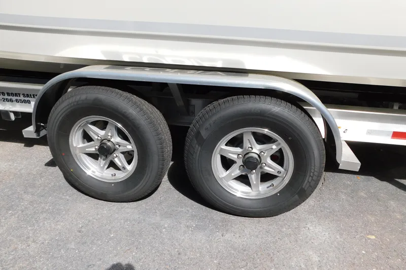 Slide: The Image of 2026 Cobia 285 Center Console boat on trailer, surrounded by palm trees. - 52