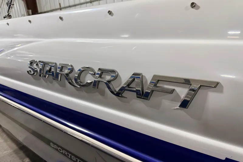 Slide: The Image of 2014 Starcraft 2000 IO Limited boat with chrome logo on white hull. - 10