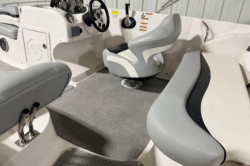 Slide: The Image of Interior of 2014 Starcraft 2000 IO Limited boat with gray seating and steering console. - 12