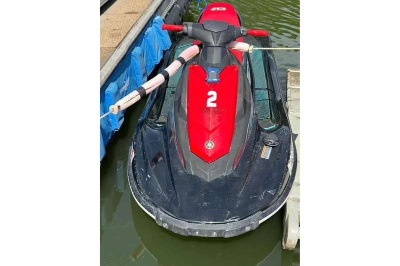 Slide: The Image of 2024 Yamaha WaveRunner EX Sport, red and black, docked on water. - 2
