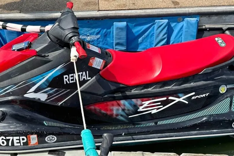 Slide: The Image of 2024 Yamaha WaveRunner EX Sport with red seat, docked and available for rental. - 3
