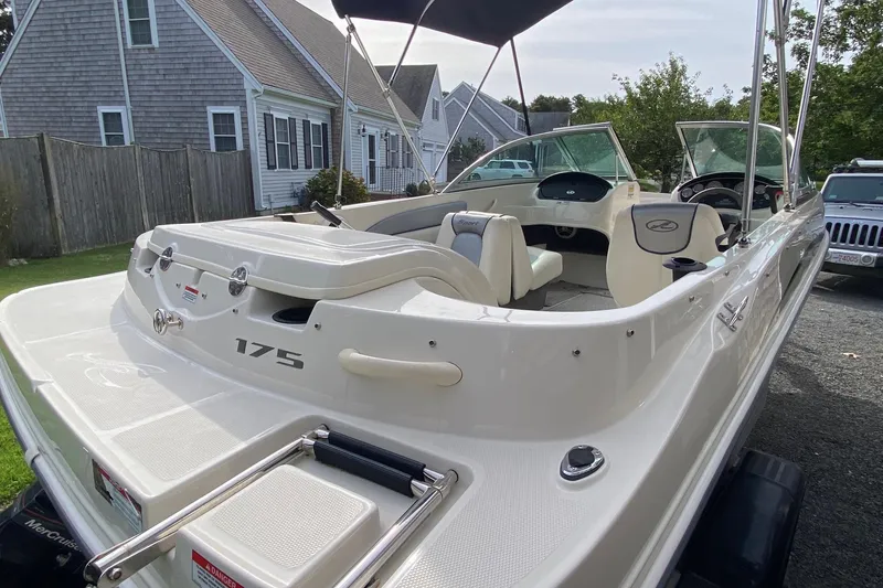 Slide: The Image of 2008 Sea Ray 175 Sport boat parked near houses, showcasing sleek design and spacious interior. - 4