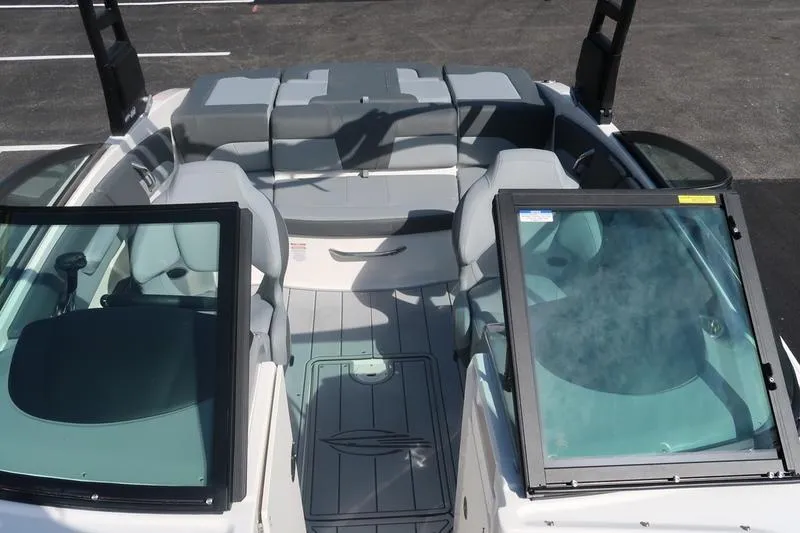 The Image of 2026 Chaparral 21 SSi boat in showroom, blue and white design on trailer. - 1