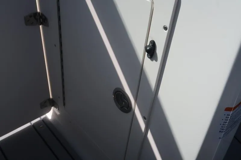 Slide: The Image of Interior storage area of 2026 Chaparral 21 SSi boat with black mat and blue cover. - 24