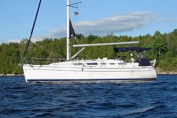 The Image of 2006 Hunter 38 sailboat on calm water, with clear sky and shoreline in background. - 0