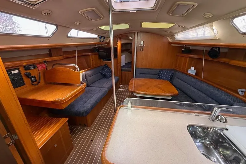 Slide: The Image of Interior of 2006 Hunter 38 sailboat with wood finish and blue seating. - 17