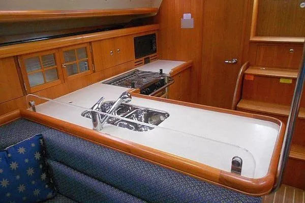 Slide: The Image of Interior of 2006 Hunter 38 yacht with blue cushioned seating and wooden finish. - 26