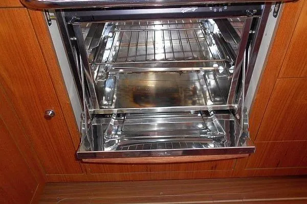 Slide: The Image of Interior of a 2006 Hunter 38 sailboat with blue cushioned seating and wooden finishes. - 31