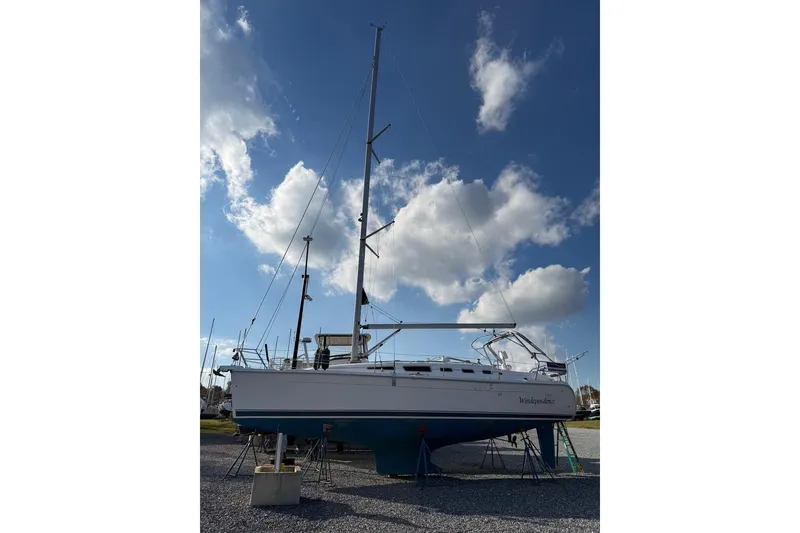 Slide: The Image of Open refrigerator inside a 2006 Hunter 38 yacht, featuring wooden flooring and cabinetry. - 42