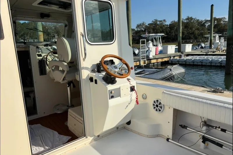 Slide: The Image of 2006 Parker 2520 XL Sport Cabin boat interior with steering wheel at marina. - 11