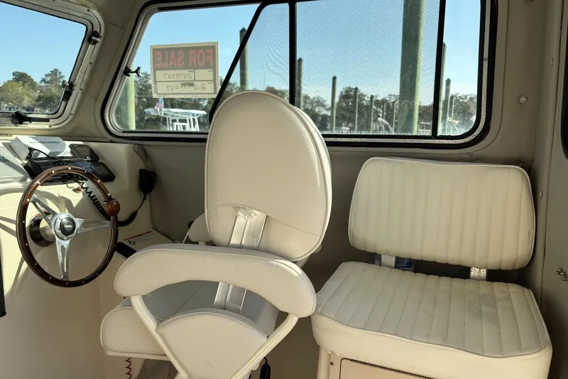 Slide: The Image of Interior of 2006 Parker 2520 XL Sport Cabin boat with steering wheel and seats. - 6