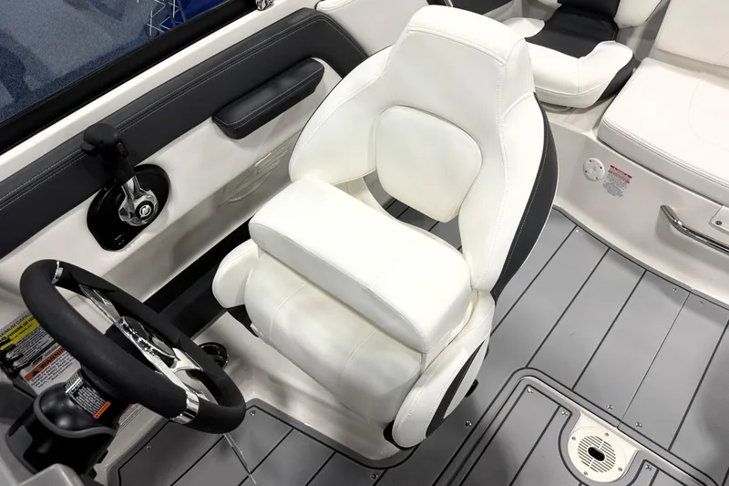 Slide: The Image of 2026 Chaparral 21 SSi Ski & Fish boat interior with white captain's seat and steering wheel. - 21