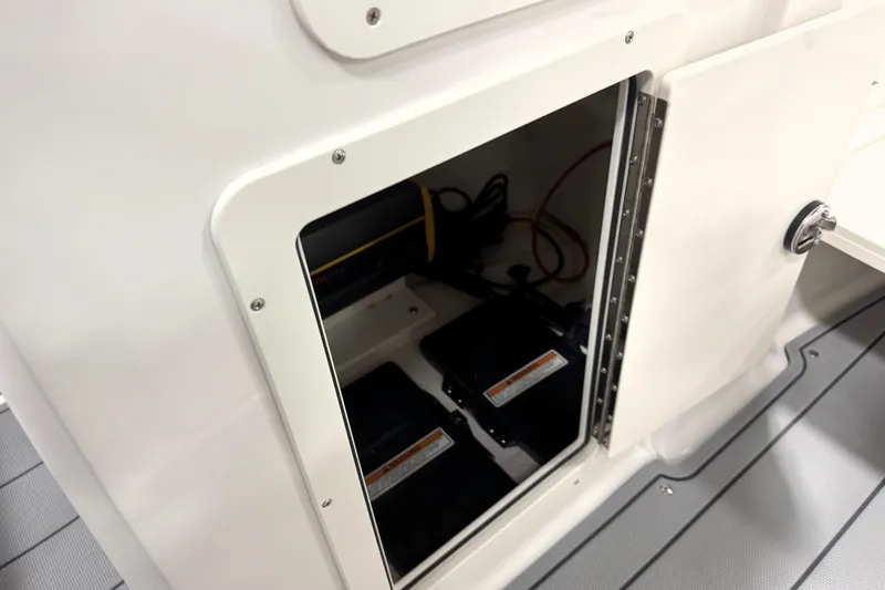 Slide: The Image of 2026 Chaparral 21 SSi Ski & Fish boat battery compartment with open access door. - 26