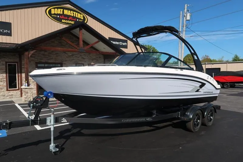 Slide: The Image of 2026 Chaparral 21 SSi boat on trailer, parked outdoors under a clear sky. - 2