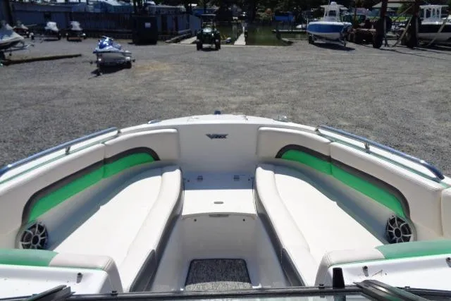 Slide: The Image of 2018 Chaparral Vortex 243 VRX boat interior with white and green seating at a marina. - 6