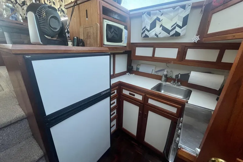 Slide: The Image of Compact kitchen in 1990 Cooper Prowler 35 boat with fridge, sink, and microwave. - 10