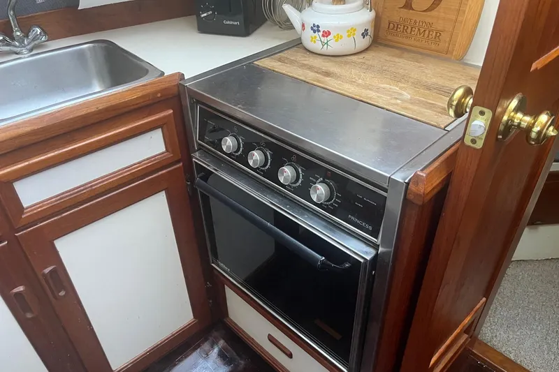 Slide: The Image of Compact kitchen area in a 1990 Cooper Prowler 35 boat with stove and sink. - 11