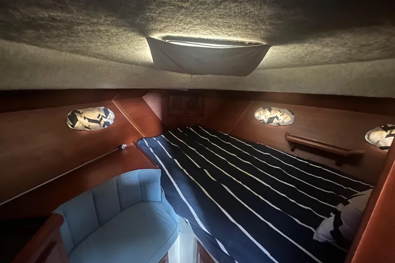 Slide: The Image of Cozy cabin interior of 1990 Cooper Prowler 35 with striped bedding and wooden accents. - 12