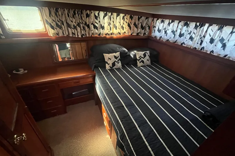 Slide: The Image of Cozy bedroom in 1990 Cooper Prowler 35 yacht with striped bedding and wooden furnishings. - 13