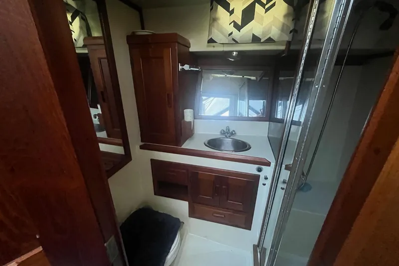 Slide: The Image of Bathroom interior of 1990 Cooper Prowler 35 with wooden cabinets and sink. - 14
