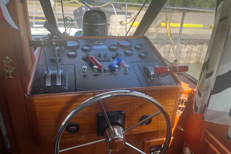 Slide: The Image of Control panel of a 1990 Cooper Prowler 35 boat with steering wheel and throttle levers. - 18