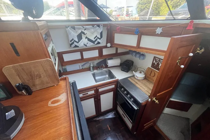 Slide: The Image of Cozy kitchen in 1990 Cooper Prowler 35 boat with wood cabinetry and compact appliances. - 9