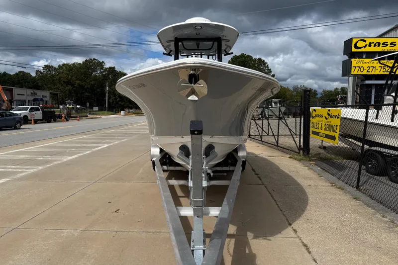 Slide: The Image of 2021 Sea Hunt Gamefish 27 boat on trailer at dealership, overcast sky. - 2