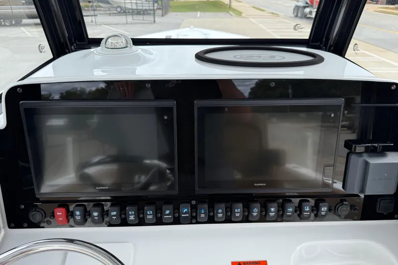 Slide: The Image of 2021 Sea Hunt Gamefish 27 dashboard with dual Garmin displays and control switches. - 26