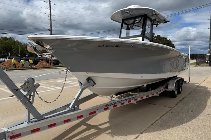 Slide: The Image of 2021 Sea Hunt Gamefish 27 boat on trailer, parked outdoors under cloudy sky. - 3