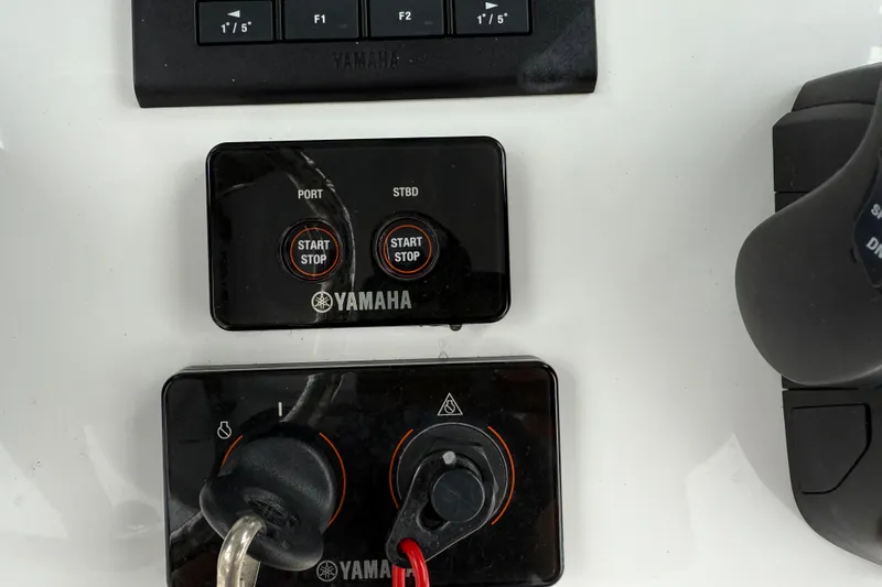 Slide: The Image of Yamaha controls on 2021 Sea Hunt Gamefish 27 boat dashboard, featuring start/stop buttons. - 32