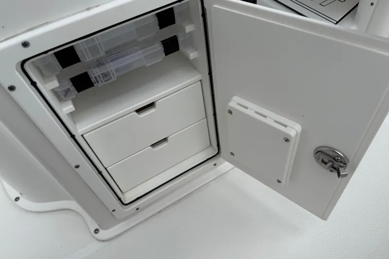Slide: The Image of 2021 Sea Hunt Gamefish 27 storage compartment with open door and organized drawers. - 49
