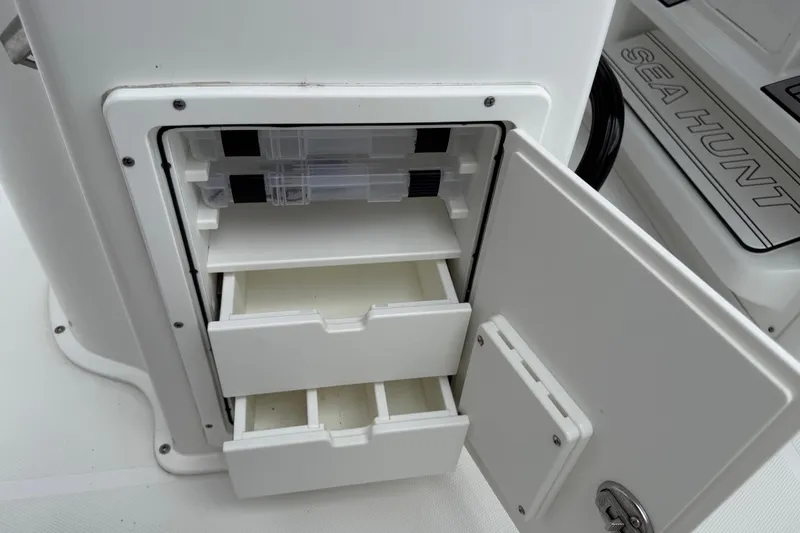 Slide: The Image of Open storage compartment on 2021 Sea Hunt Gamefish 27 boat with drawers and tackle boxes. - 50