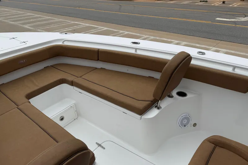 Slide: The Image of 2021 Sea Hunt Gamefish 27 Forward Seating with brown cushions, docked near a road. - 8