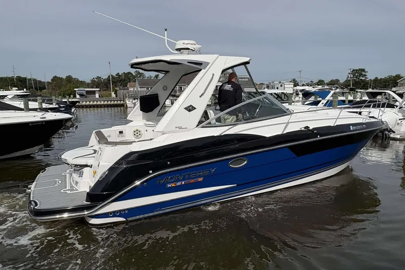 Slide: The Image of 2020 Monterey 355 Sport Yacht in marina, sleek design, blue and white exterior. - 2